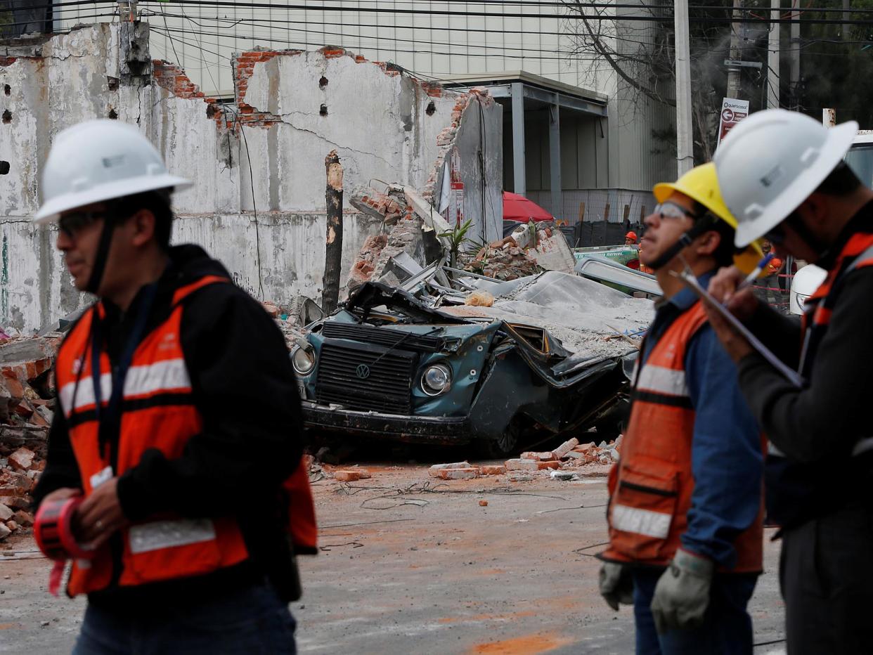 Workers survey the aftermath in Mexico City: REUTERS