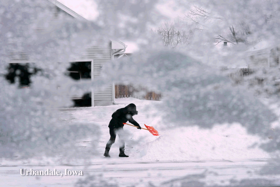 A resident shovels snow off the end of a driveway in Urbandale, Iowa contrast with visitors at Shoreline Aquatic Park