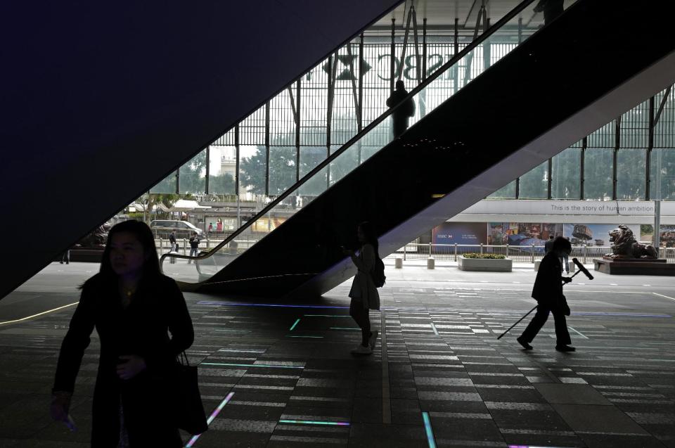 People walk past the HSBC's Hong Kong headquarters in Hong Kong, Tuesday, Feb. 21, 2017. London-based bank HSBC reported Tuesday that annual profit slumped following a year it said would be remembered for "unexpected economic and political events" and warned of risks in 2017 to the global economy's continuing recovery. (AP Photo/Vincent Yu)