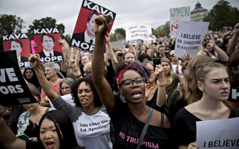 A protest in support of Christine Blasey Ford. Women hold signs reading "Kavanope" and "I believe her" - Credit: Andrew Harrer/Bloomberg