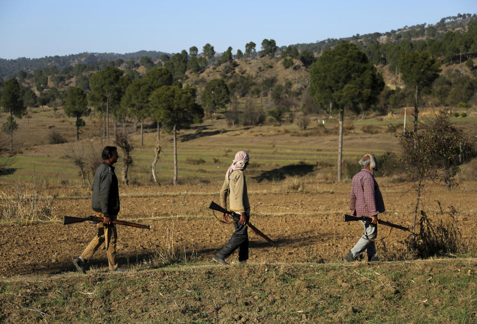 Members of a local militia called Village Defense Committees, that have been formed to aid the Indian army in keeping a close watch of the India-Pakistan border, walk near the Line of Control, at Jhangad Village in Naushera, India, Thursday, Dec. 17, 2020. From sandbagged Indian army bunkers dug deep into the Pir Panjal mountains in the Himalayas, villages on the Pakistan-controlled side of Kashmir appear precariously close, on the other side of the Line of Control that for the past 73 years has divided the region between the two nuclear-armed rivals. Tens of thousands of soldiers from India and Pakistan are positioned along the two sides. The apparent calm is often broken by the boom of blazing guns, with each side accusing the other of initiating the firing. (AP Photo/Channi Anand)