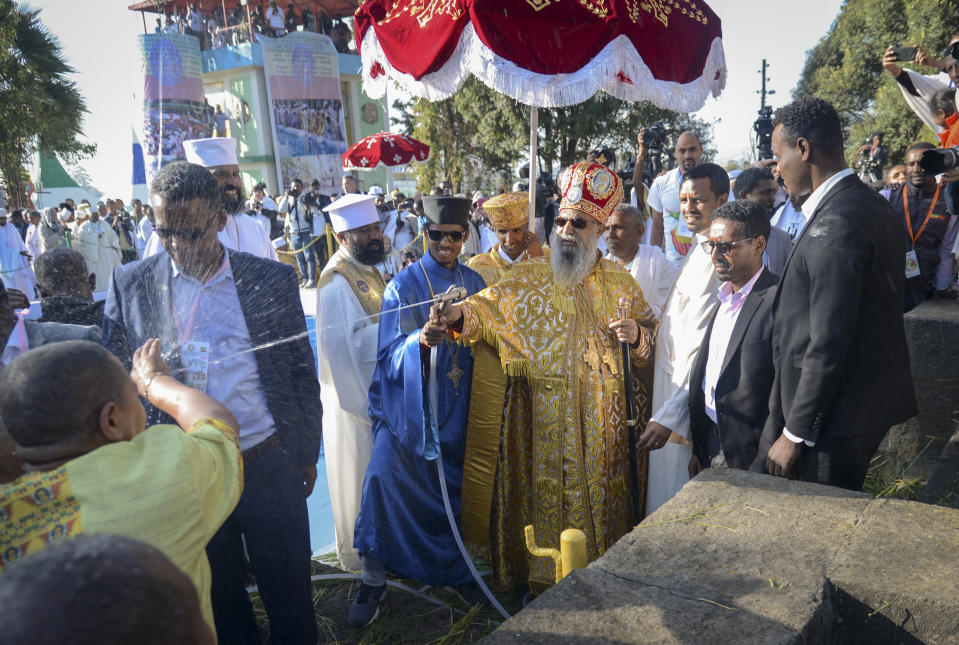 Patriarch of the Ethiopian Orthodox Church, Abune Mathias, sprays holy water on Christians as they celebrate the annual festival of Timkat, or Epiphany, marking the baptism of Jesus Christ in the River Jordan, in the capital Addis Ababa, Ethiopia Monday, Jan. 20, 2020. During Timkat celebrations elsewhere in the country, in the city of Gondar, at least three people are dead after a wooden stand erected for the event collapsed on Monday, according to a hospital source. (AP Photo)