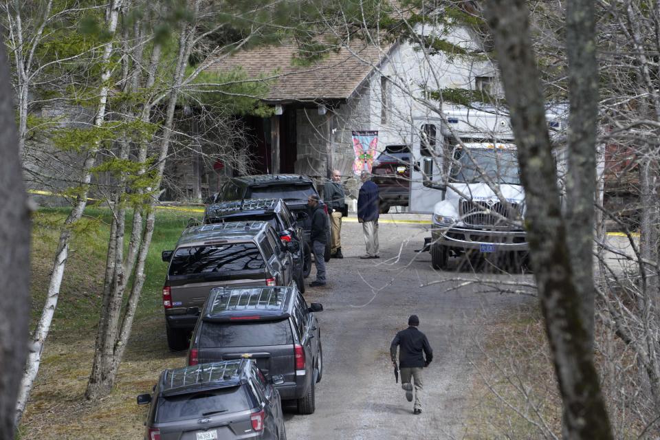 Investigators work at the scene of a deadly shooting, Tuesday, April 18, 2023, in Bowdoin, Maine. State police in Maine say gunfire that erupted on busy highway is linked to a second crime scene where four people were found dead in a home about 25 miles away. (AP Photo/Robert F. Bukaty)