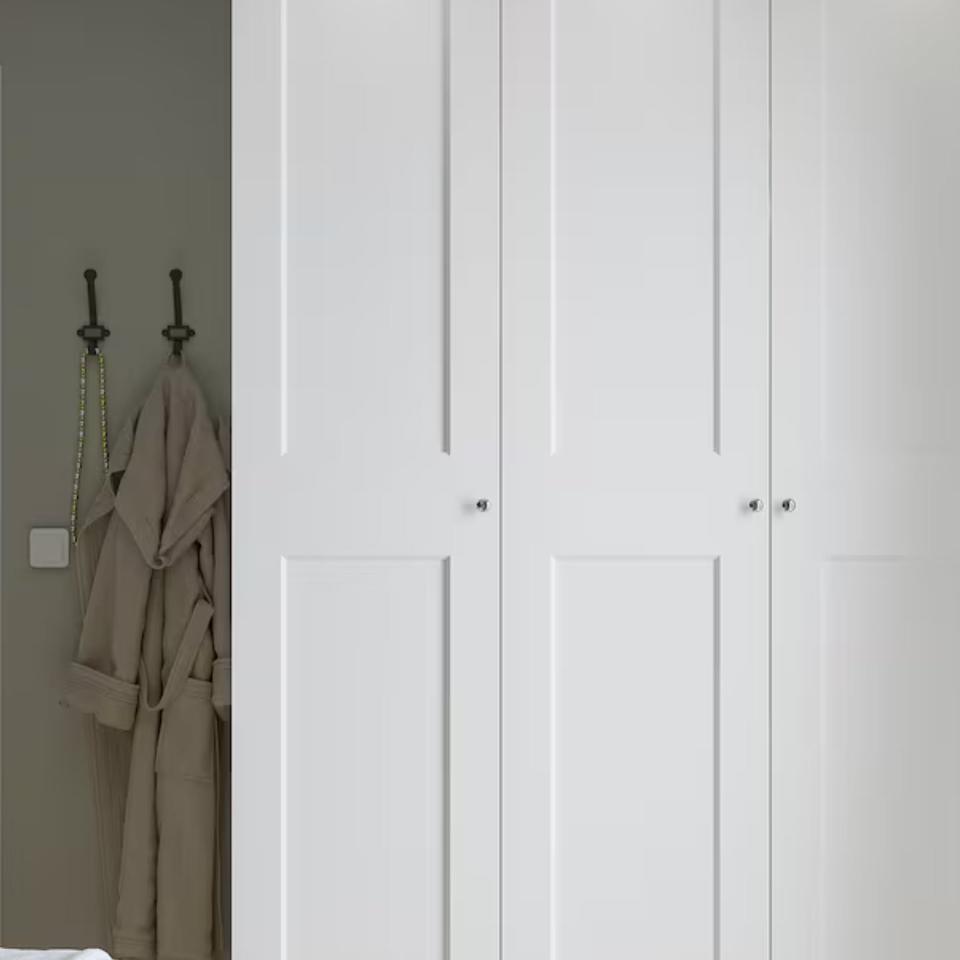 Une armoire blanche à portes battantes pour un dressing de rêve