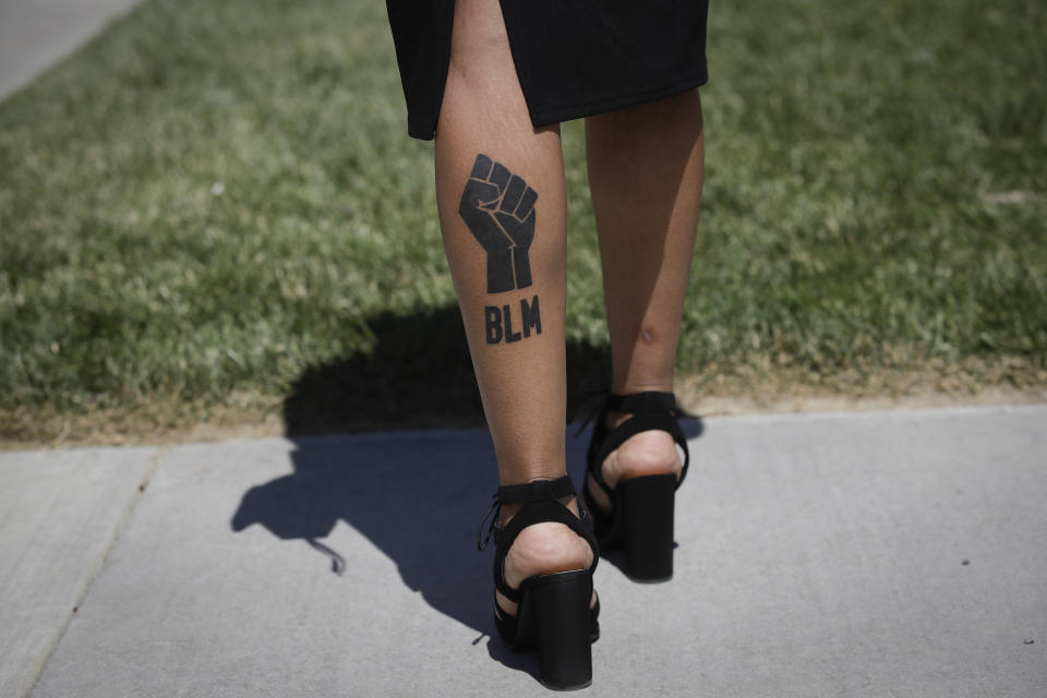 Shaneeze Flax has a Black Lives Matter tattoo on her calf as she attends a funeral for Robert Fuller on Tuesday, June 30, 2020, in Littlerock, Calif. Fuller, a 24-year-old Black man, was found hanging from a tree in a park in a Southern California high desert city. Authorities initially said the death of Fuller appeared to be a suicide but protests led to further investigation, which continues. (AP Photo/Marcio Jose Sanchez)