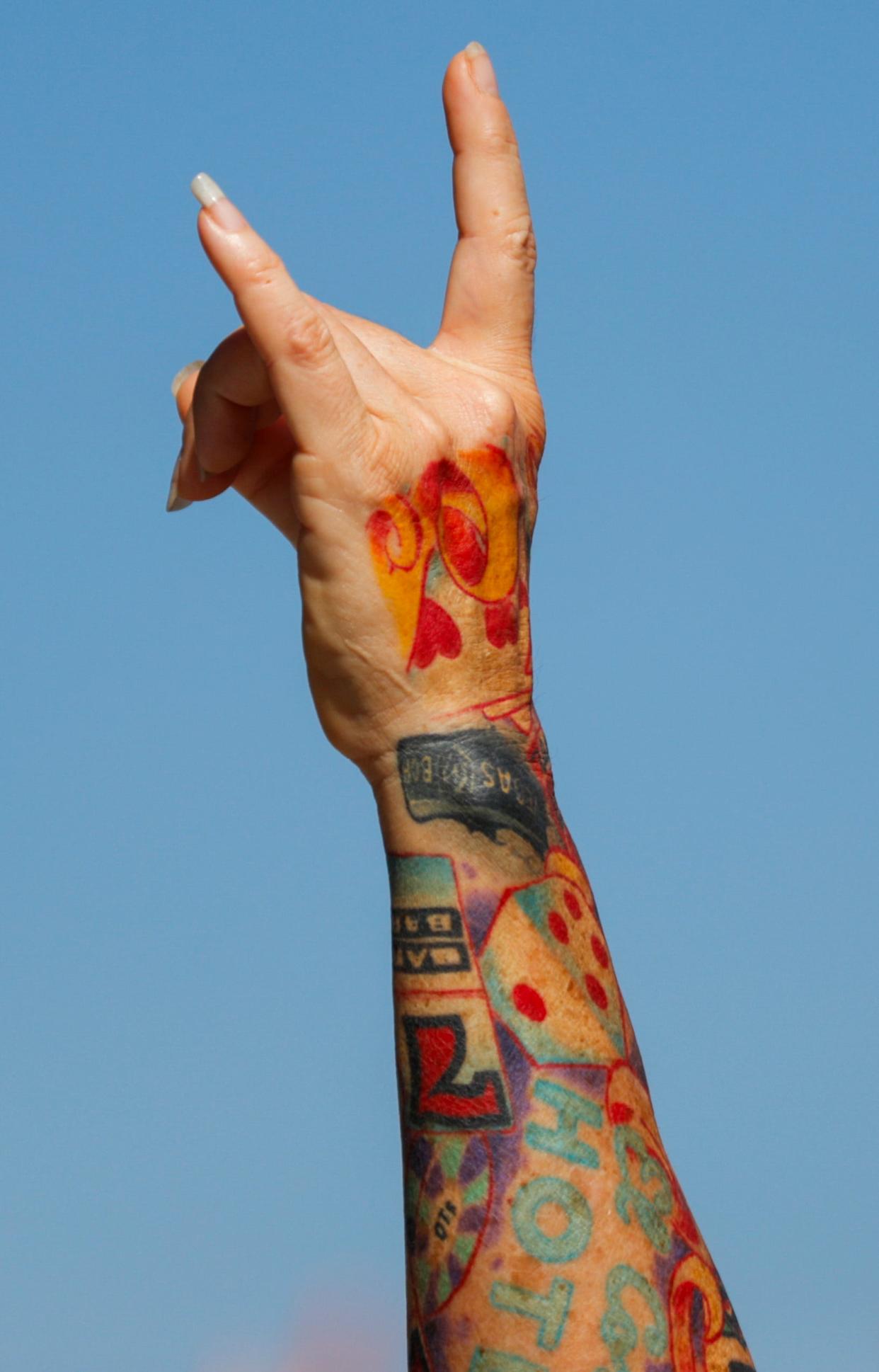 A fans' tattooed arm threw up horns at Friday's Louder Than Life music festival. Sept. 22, 2023