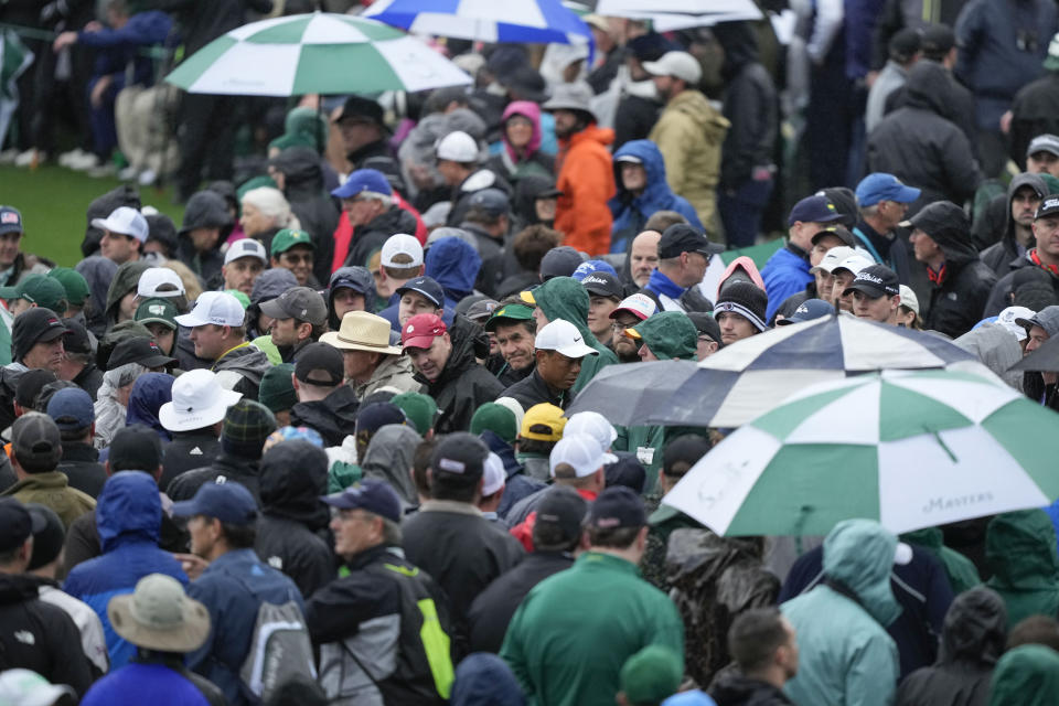 Tiger Woods walks through the gallery on the 18th hole during the weather delayed second round of the Masters golf tournament at Augusta National Golf Club on Saturday, April 8, 2023, in Augusta, Ga. (AP Photo/David J. Phillip)