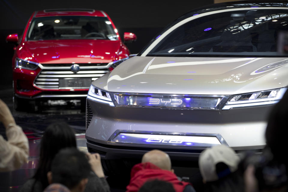 FILE - In this April 25, 2018, file photo, attendees take photos of the E-SEED electric concept car during a press conference by Chinese automaker BYD at the China Auto Show in Beijing. The 2019 Shanghai auto show highlights the global industry's race to transform electric cars into a profitable product Chinese drivers want to buy as Beijing winds down multibillion-dollar subsidies that made this country the biggest market for the technology. (AP Photo/Mark Schiefelbein, File)