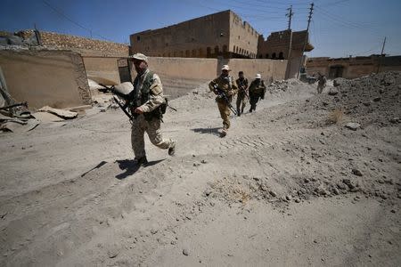 Shi'ite Popular Mobilization Forces (PMF) members carry their weapons at Al Jazeera neighbourhood of Tal Afar, Iraq, August 23, 2017. REUTERS/Stringer