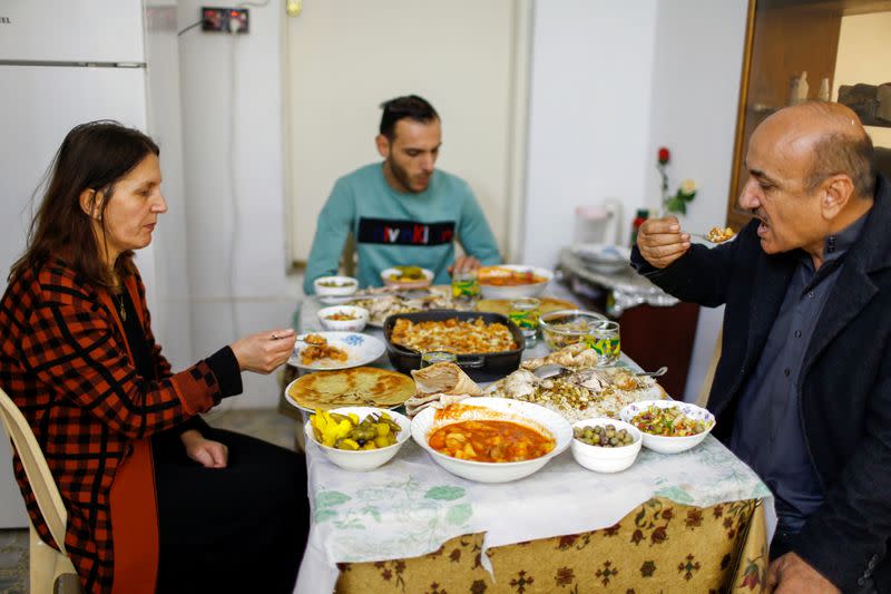 Thanoun Yahya, an Iraqi Christian eats food with his wife and his son at his home which he reclaimed when Islamic State militants was driven out, in Mosul