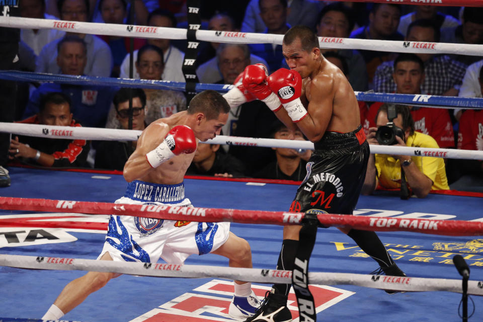 In this July 27, 2013 photo, Mexico's Juan Francisco Estrada, left, fights against Milan Melindo of the Philippines during their WBO/WBA Flyweight title match at the Cotai Arena in Venetian Macao in Macau. A Chinese fighter’s victory at a Macau showdown brings the world’s top casino market a step closer to challenging Las Vegas for dominance of another Sin City staple: big-time boxing matches. Macau, which long ago eclipsed Vegas as the world's top gambling city, is now looking to add to its allure by holding the kind of boxing bouts that Las Vegas is known for. (AP Photo/Dennis Ho)