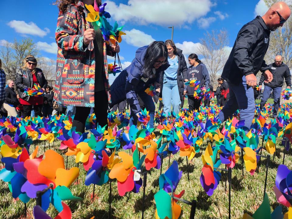 Law enforcement, child care advocacy centers, school representatives and community representatives plant pinwheels in Amarillo, Texas, on April 2, 2024, to mark Child Abuse Prevention Month.