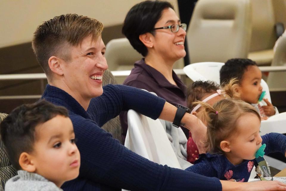 Dr. Erin Meyer and her wife and Dr. Sandra Medinilla sit with their four adopted children during an adoption ceremony for their fourth child, 6-month-old Sydney.