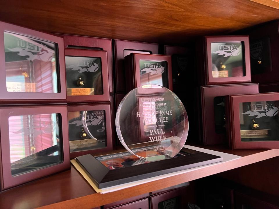 Paul Wulf's tennis trophies and awards are displayed on bookshelves in his home office.