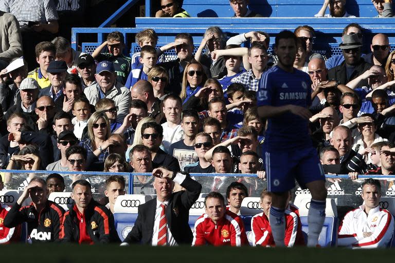 Manchester United's manager Louis van Gaal (3rd L) and assistant manager Ryan Giggs (2nd L) watch the action from the bench during their English Premier League match against Chelsea, at Stamford Bridge in London, on April 18, 2015