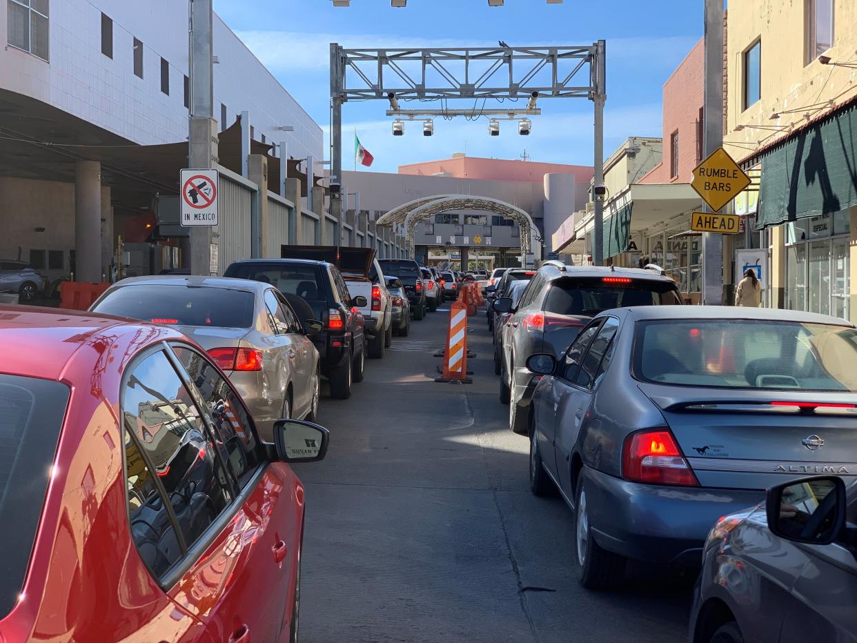 Lines of Mexico-bound cars wait for the chance to cross the U.S.-Mexico border at the DeConcini port of entry in the twin border cities of Ambos Nogales on Dec. 17, 2020. Inspections by Mexican customs officers has increased crossing times as more Mexican Americans head to Mexico to spend the holidays with relatives, despite restrictions on nonessential travel at the border.