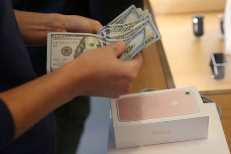 A customer buys the new iPhone 7 smartphone inside an Apple Inc. store in Los Angeles, California, U.S., September 16, 2016. REUTERS/Lucy Nicholson - RTSO2OM