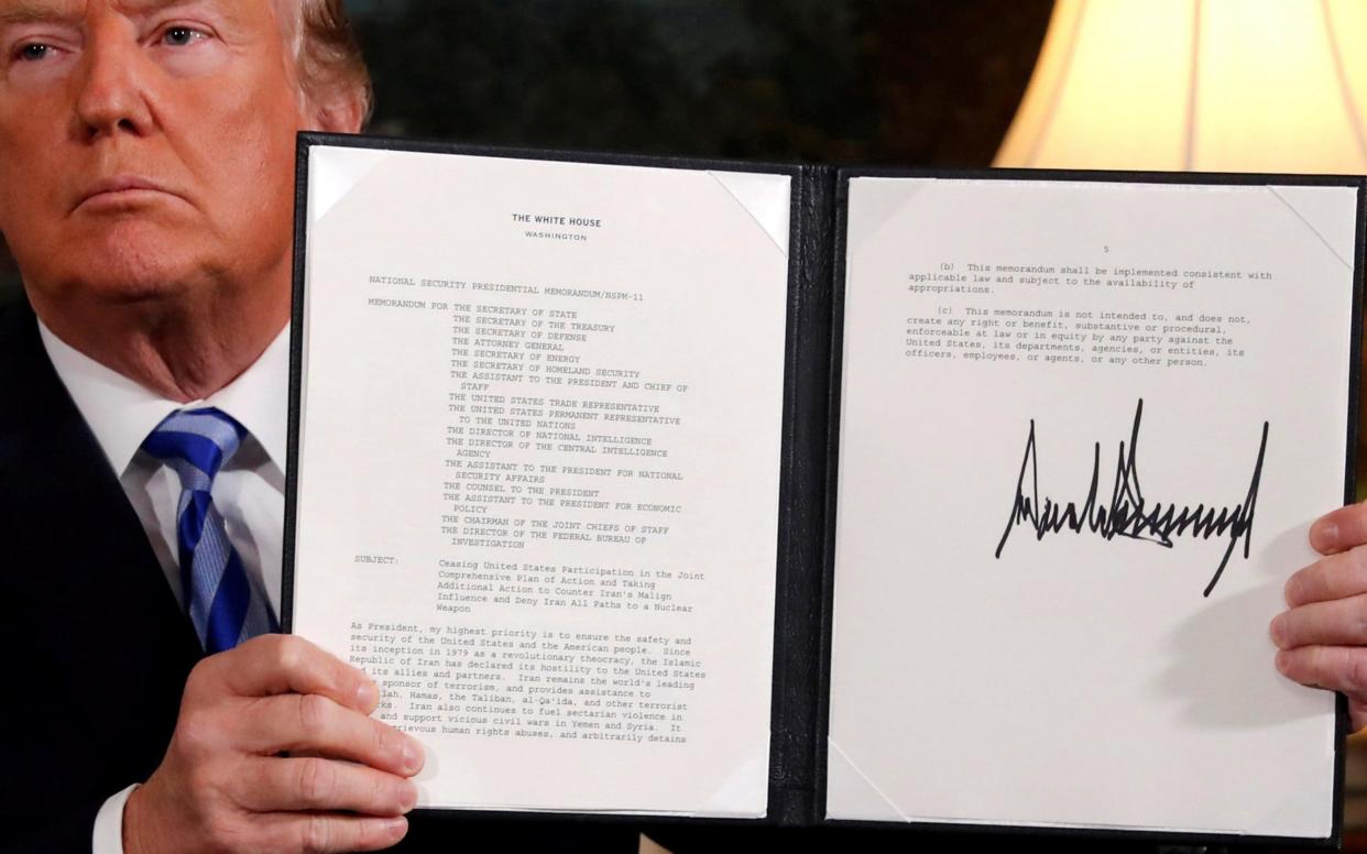 US President Donald Trump holds up a proclamation declaring his intention to withdraw from the JCPOA Iran nuclear agreement - REUTERS