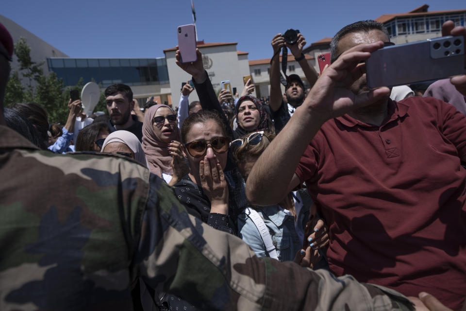 Palestinian mourners follow the body of slain Al Jazeera journalist Shireen Abu Akleh who was shot dead Wednesday during an Israeli military raid in the West Bank city of Jenin, during an official ceremony at the Palestinian Authority headquarters in Ramallah, Thursday, May 12, 2022. Thousands gathered to mourn Abu Akleh in the occupied West Bank city of Ramallah on Thursday, as the head of the Palestinian Authority blamed Israel for her death and rejected Israeli calls for a joint investigation. (AP Photo/Nasser Nasser)