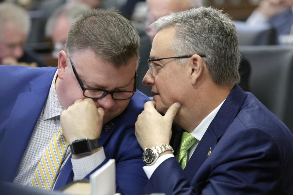 Rep. Jason Saine, R-Lincoln, left, and Sen. Jim Perry, R-Beaufort, right, confer on the House floor as lawmakers debate over redistricting bills at the Legislative Building, Tuesday, Oct. 24, 2023, in Raleigh, N.C. (AP Photo/Chris Seward)