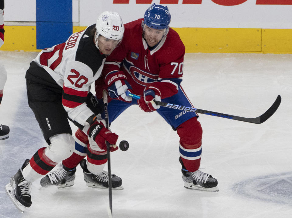 New Jersey Devils' Michael McLeod (20) and Montreal Canadiens' Tanner Pearson (70) vie for the puck during the first period of an NHL hockey game Tuesday, Oct. 24. 2023, in Montreal. (Christinne Muschi/The Canadian Press via AP)