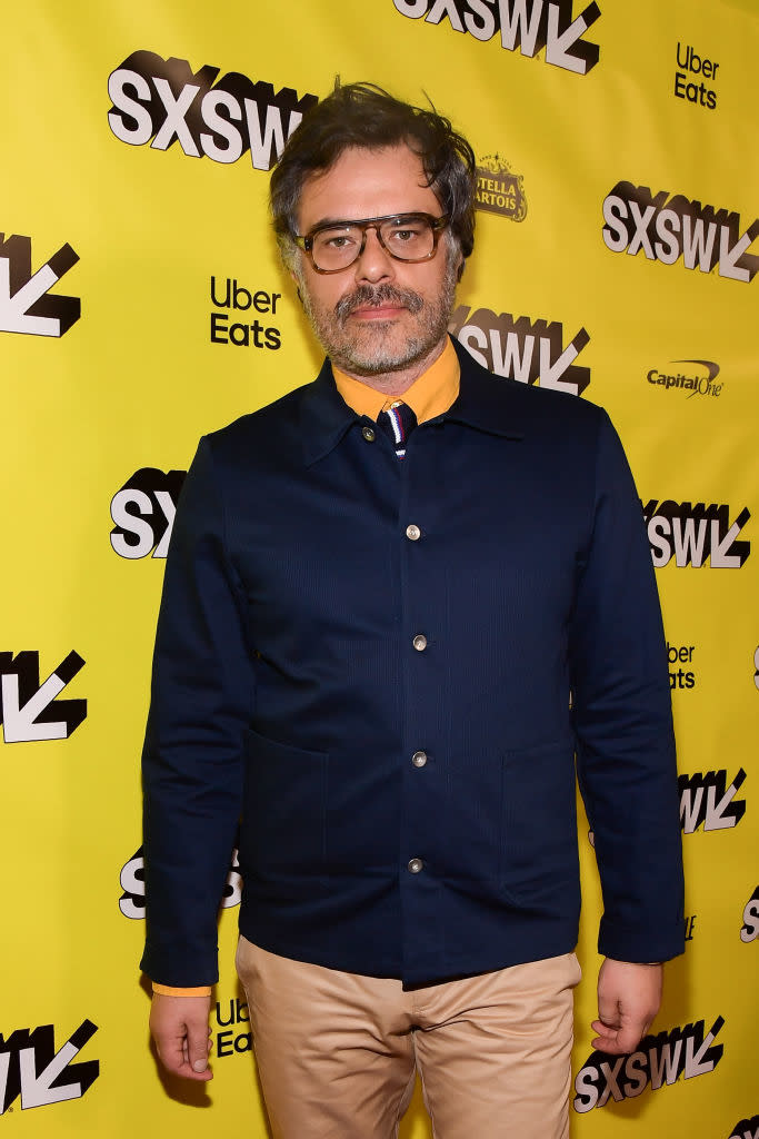 Man in a dark jacket over a collared shirt with hands in pockets at the SXSW event