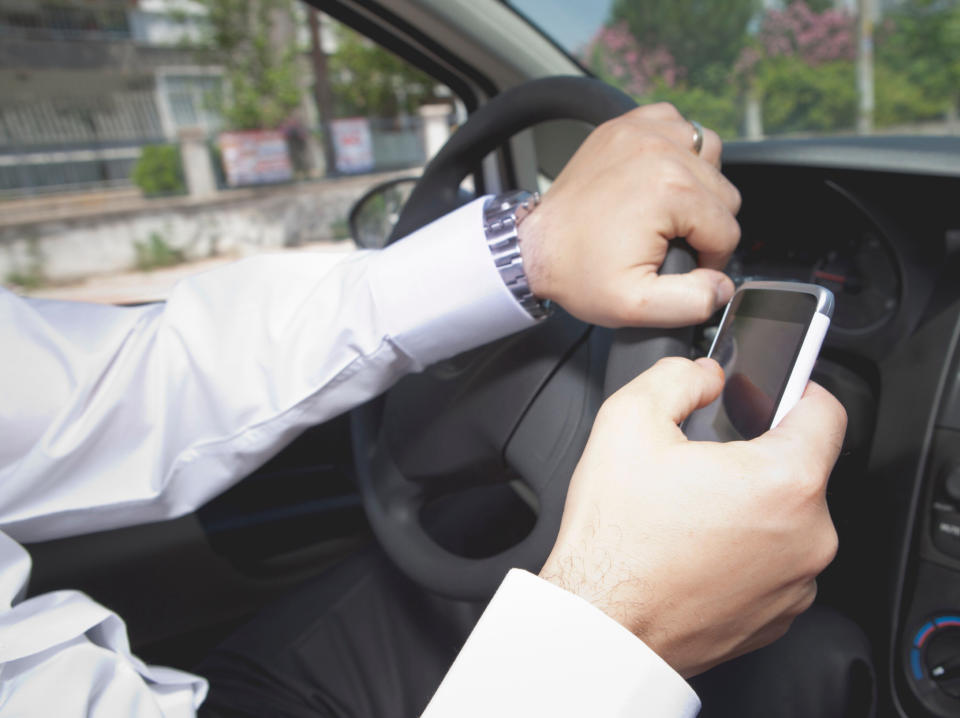 Wer mit dem Handy am Steuer einen Unfall baut, handelt fahrlässig. Eine Kfz-Versicherung kann deshalb ohne entsprechende Klausel die Zahlung verweigern. (Bild: Getty Images)