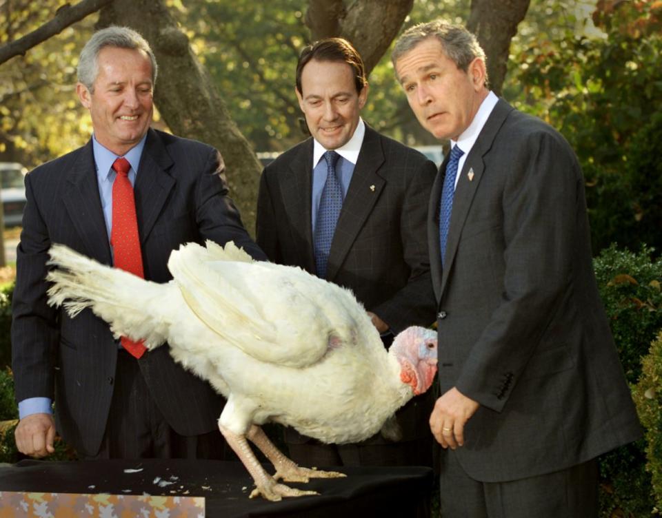 <p>President George W. Bush reacts to a turkey named “Liberty” at the annual turkey pardoning event at the White House, three days ahead of Thanksgiving on Nov. 19, 2001. The fortunate bird will spend the rest of his days on a farm in Virginia. With the president are turkey industry representatives Jeff Radford (left) and Stuart Proctor. (Photo: Kevin Lamarque/Reuters) </p>