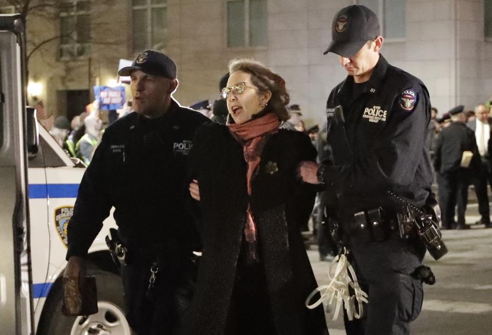 A protester is taken into custody outside Trump International Hotel & Tower on Friday, Feb. 15, 2019, in New York. Some people have been arrested while protesting President Donald Trump's national emergency declaration. The NYPD wasn't immediately able to say how many people were taken into custody outside the hotel. (AP Photo/Frank Franklin II)