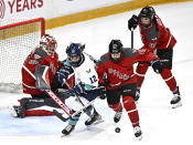 New York's Chloe Aurard (12) and Ottawa's Savannah Harmon (15) chase a rebound in front of Ottawa's Emerance Maschmeyer (38) and Lexie Adzija (88) during overtime PWHL hockey game action in Ottawa, Ontario, Sunday, Feb. 4, 2024. (Justin Tang/The Canadian Press via AP)