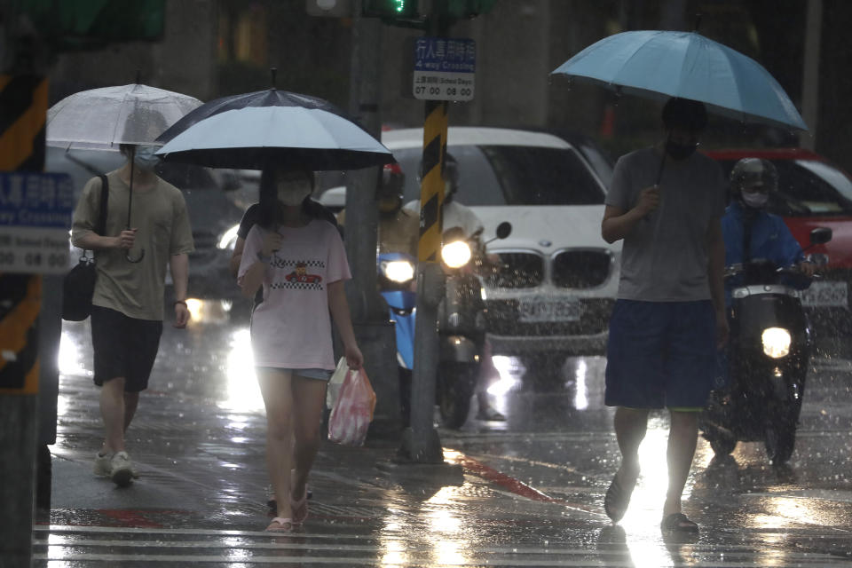 People make their ways in a rain ahead of the approaching Typhoon Hinnamnor in Taipei, Taiwan, Saturday, Sept. 3, 2022. (AP Photo/Chiang Ying-ying)