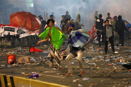 Protesters hurl stones during a riot near the Election Supervisory Agency (Bawaslu) headquarters in Jakarta, Indonesia, May 22, 2019. REUTERS/Willy Kurniawan