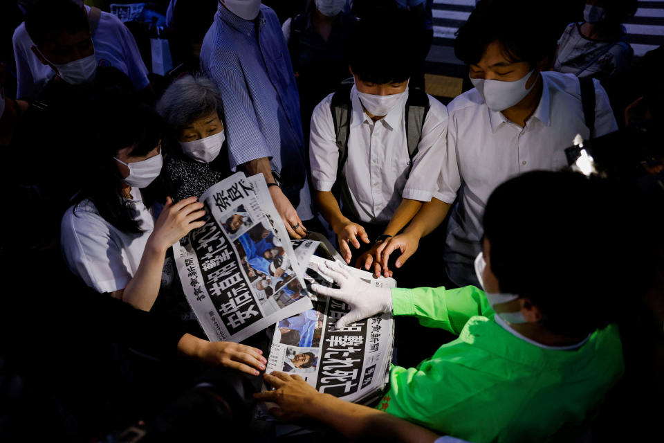 People receive a special edition of the Yomiuri Shimbun newspaper reporting the death of Japan's former Prime Minister Shinzo Abe, in Tokyo, Japan on July 8, 2022.<span class="copyright">Kim Kyung-Hoon—Reuters</span>