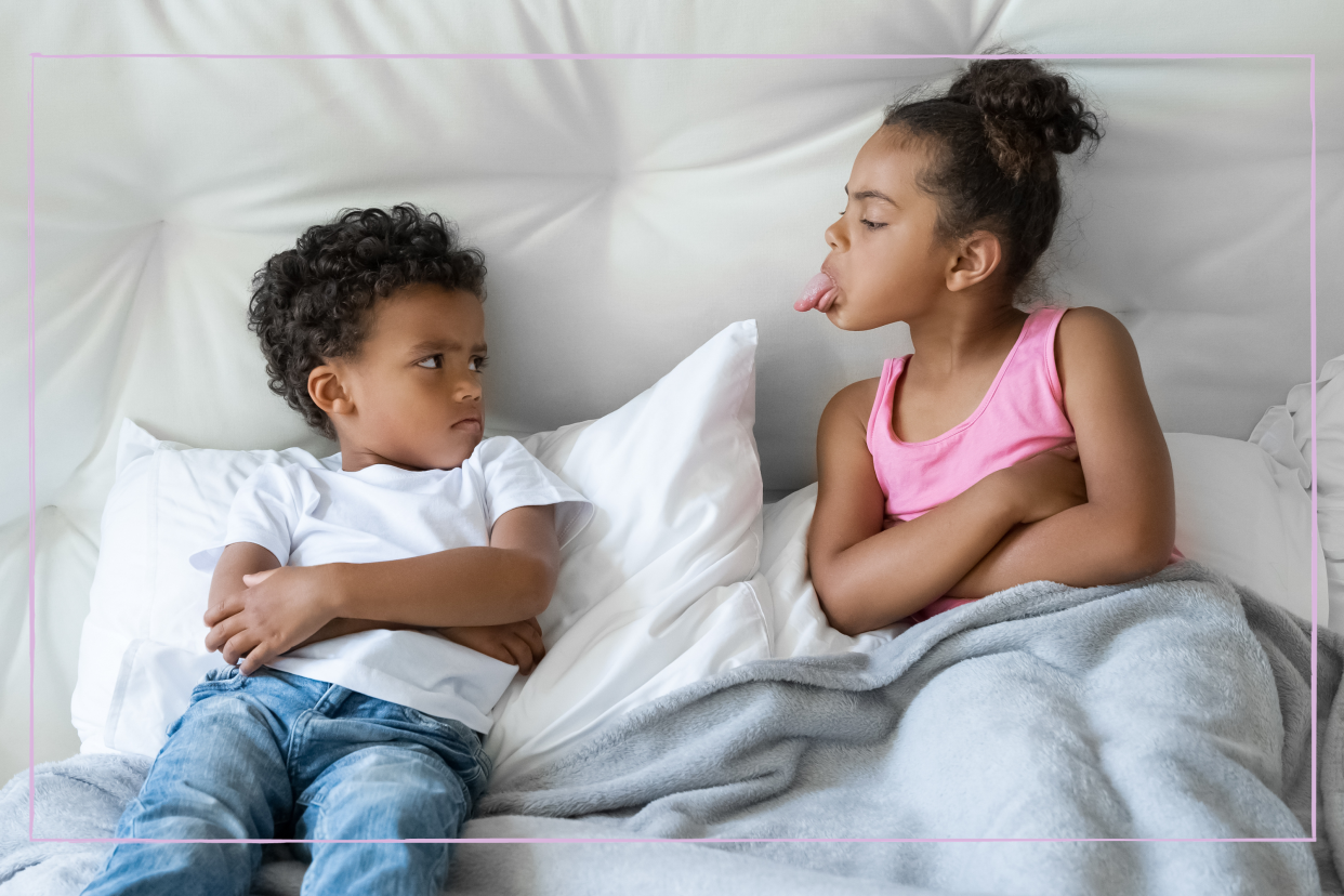  African American sister and brother little children quarrelling lying in bed. 