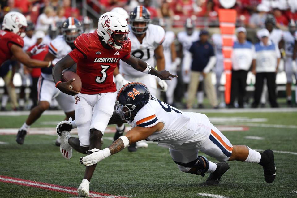 Virginia defensive tackle Aaron Faumui (94) attempts to tackle Louisville quarterback Malik Cunningham (3) during the second half of an NCAA college football game in Louisville, Ky., Saturday, Oct. 9, 2021. Virginia won 34-33. (AP Photo/Timothy D. Easley)