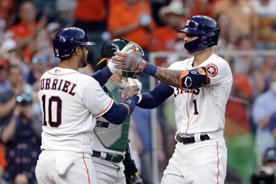 Houston Astros' Yuli Gurriel (10) and Carlos Correa (1) celebrate at the plate after Correa's home run during the second inning against the Oakland Athletics in a baseball game Thursday, April 8, 2021, in Houston. (AP Photo/Michael Wyke)