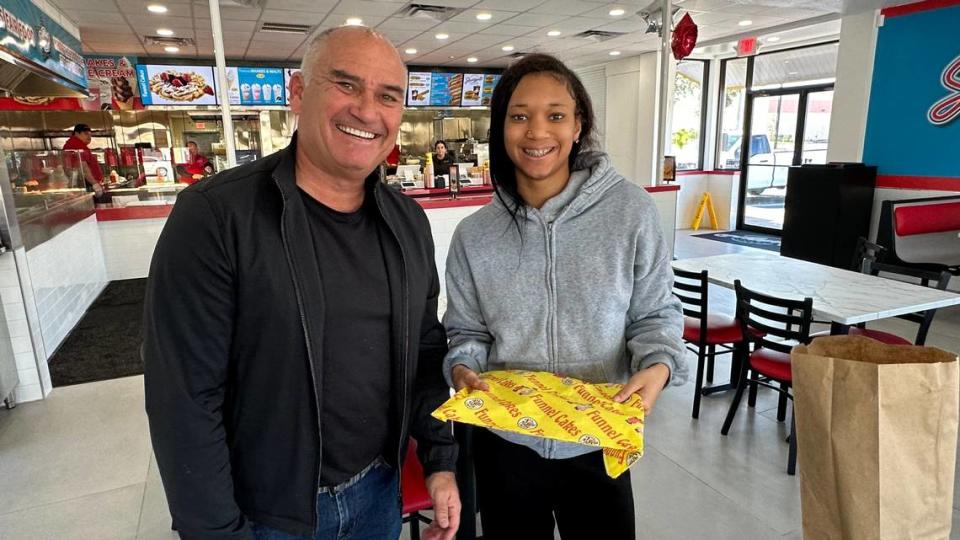 Brett Enright delivers a funnel cake order to guest Amariah Everett 11/29/2023 at Juicys​ Famous Fair Food, 2319 Cortez Road W., Bradenton. James A. Jones Jr./jajones1@bradenton.com