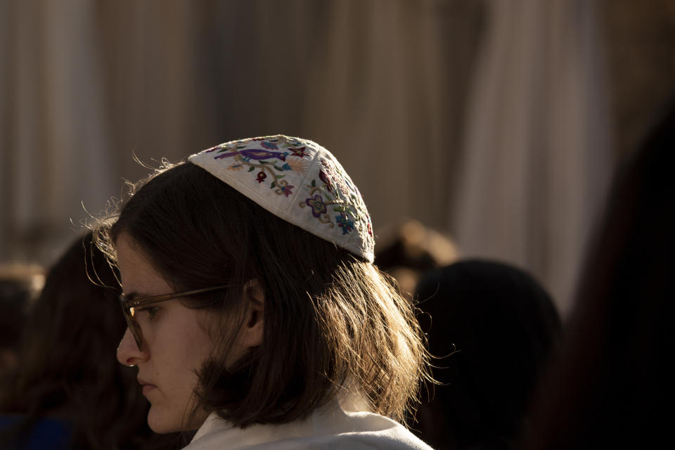 A member of the Women of the Wall wears a head covering in the women's section at the Western Wall, the holiest site where Jews can pray, in the Old City of Jerusalem, Friday, Nov. 5, 2021. Thousands of ultra-Orthodox Jews gathered at the site to protest against the Jewish women's group that holds monthly prayers there in a long-running campaign for gender equality at the site. (AP Photo/Maya Alleruzzo)