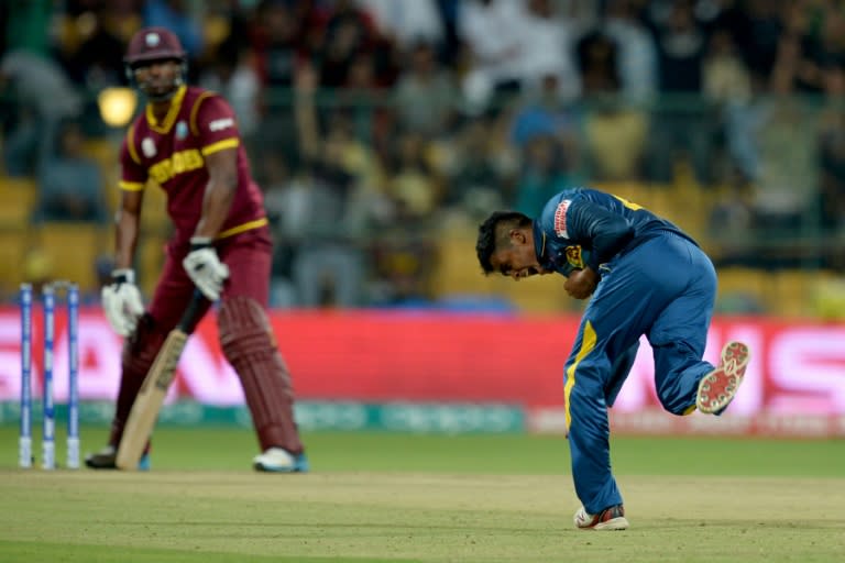 Sri Lankan bowler Jeffery Vandersay (R) celebrates the wicket of West Indies's batsman Johnson Charles during the World T20 cricket tournament at The Chinnaswamy Stadium in Bangalore on March 20, 2016