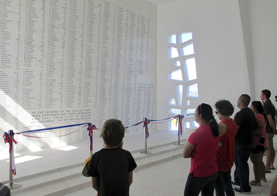 FILE - This Nov. 21, 2014 file photo shows visitors looking at a wall inscribed with the names of the USS Arizona's fallen at a memorial for the sunken battleship in Pearl Harbor, Hawaii. The CEO of a nonprofit organization that supports the National Park Service's operations in Pearl Harbor has been suspended while the group's board investigates allegations made in an anonymous letter. Pacific Historic Parks Board of Directors member and spokesman Jim Boersema said Wednesday, April 5, 2017, that Ray L'Heureux was placed on paid administrative leave last week. (AP Photo/Audrey McAvoy, File)