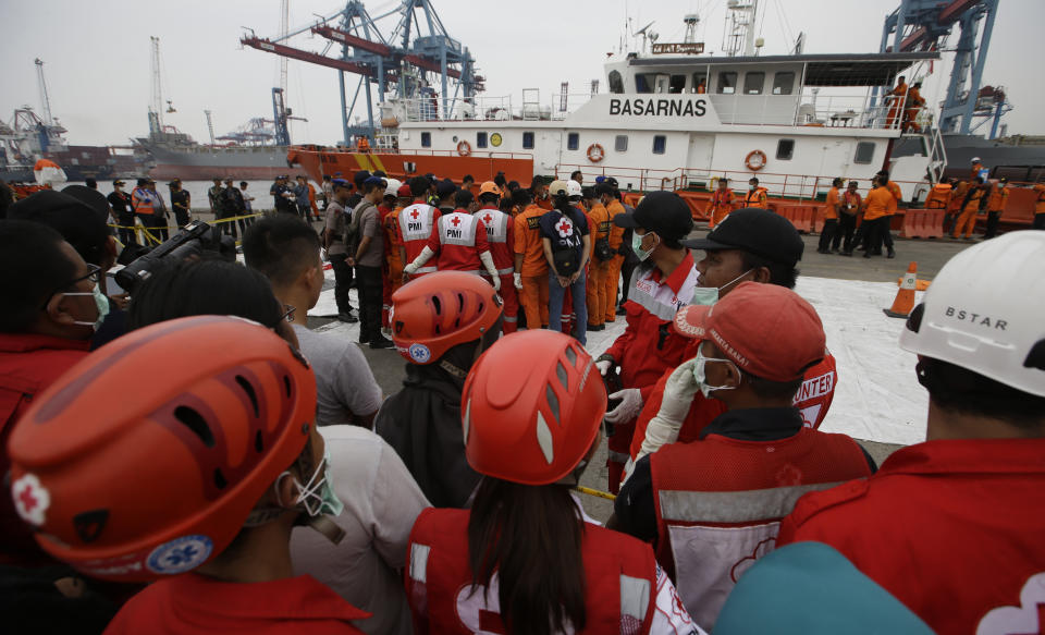 Recovery teams examine pieces of wreckage from the Lion Air jet that crashed into Java Sea at Tanjung Priok Port in Jakarta, Indonesia, Saturday, Nov. 3, 2018. New details about the crashed aircraft previous flight have cast more doubt on the Indonesian airline's claim to have fixed technical problems as hundreds of personnel searched the sea a fifth day Friday for victims and the plane's fuselage. (AP Photo/Achmad Ibrahim)