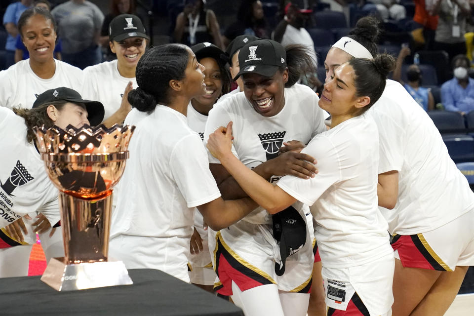 Las Vegas Aces' Chelsea Gray, center, is mobbed by her teammates as she is named MVP of the WNBA Commissioner's Cup basketball game against the Chicago Sky Tuesday, July 26, 2022, in Chicago. The Aces won 93-83. (AP Photo/Charles Rex Arbogast)