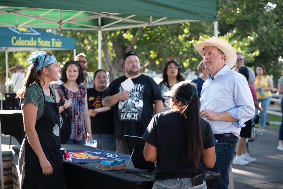 Gov. Jared Polis waits for a sample at the Grateful Planet Foods food truck during the Governor's Plate Competition at the Colorado State Fair on Tuesday, August 29, 2023.