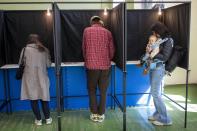 Local residents fills their ballots at a polling station during the first round of voting in presidential elections in Vilnius, Lithuania, Sunday, May 12, 2024. (AP Photo/Mindaugas Kulbis)