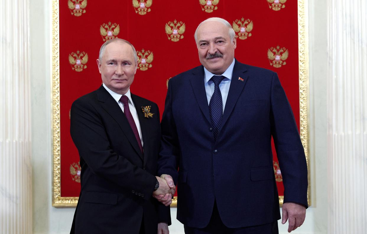Putin shakes hands with Lukashenko during their meeting at the Kremlin before the parade (EPA)