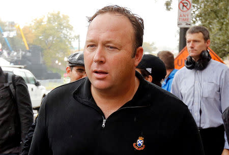 FILE PHOTO: Conspiracy theorist, radio talk show host and Infowars.net founder Alex Jones walks up Elm Street past the spot where U.S. President John F. Kennedy was assassinated in Dealey Plaza in 1963 one day before commemorations of the 50th anniversary of the assassination in Dallas, Texas, U.S., November 21, 2013. REUTERS/Jim Bourg/File Photo