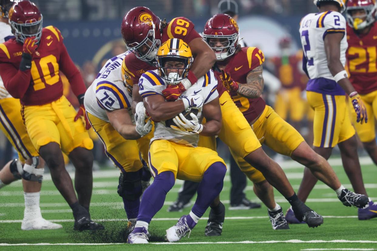 LSU Tigers running back Kaleb Jackson is tackled by USC Trojans defensive tackle Nate Clifton.