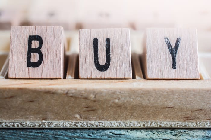 A closeup of the word buy formed by wooden blocks.