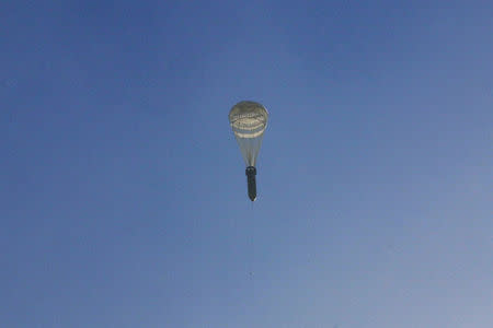 A bomb hangs on a parachute while falling over the rebel-held besieged al-Qaterji neighbourhood of Aleppo, Syria. REUTERS/Abdalrhman Ismail