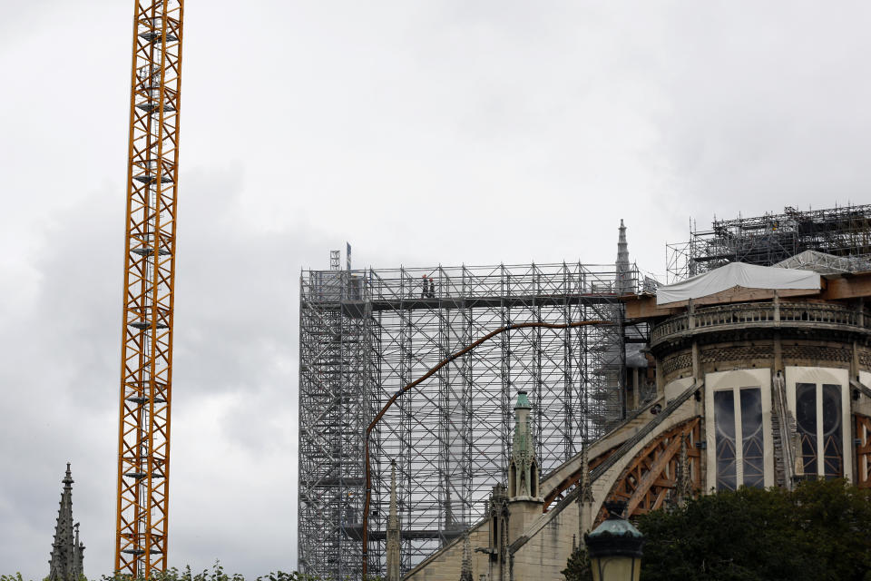 Workers walk through a scaffolding at Notre Dame cathedral, Friday, July 10, 2020 in Paris. Notre Dame Cathedral will be rebuilt just the way it stood before last year's devastating fire. (AP Photo/Thibault Camus)